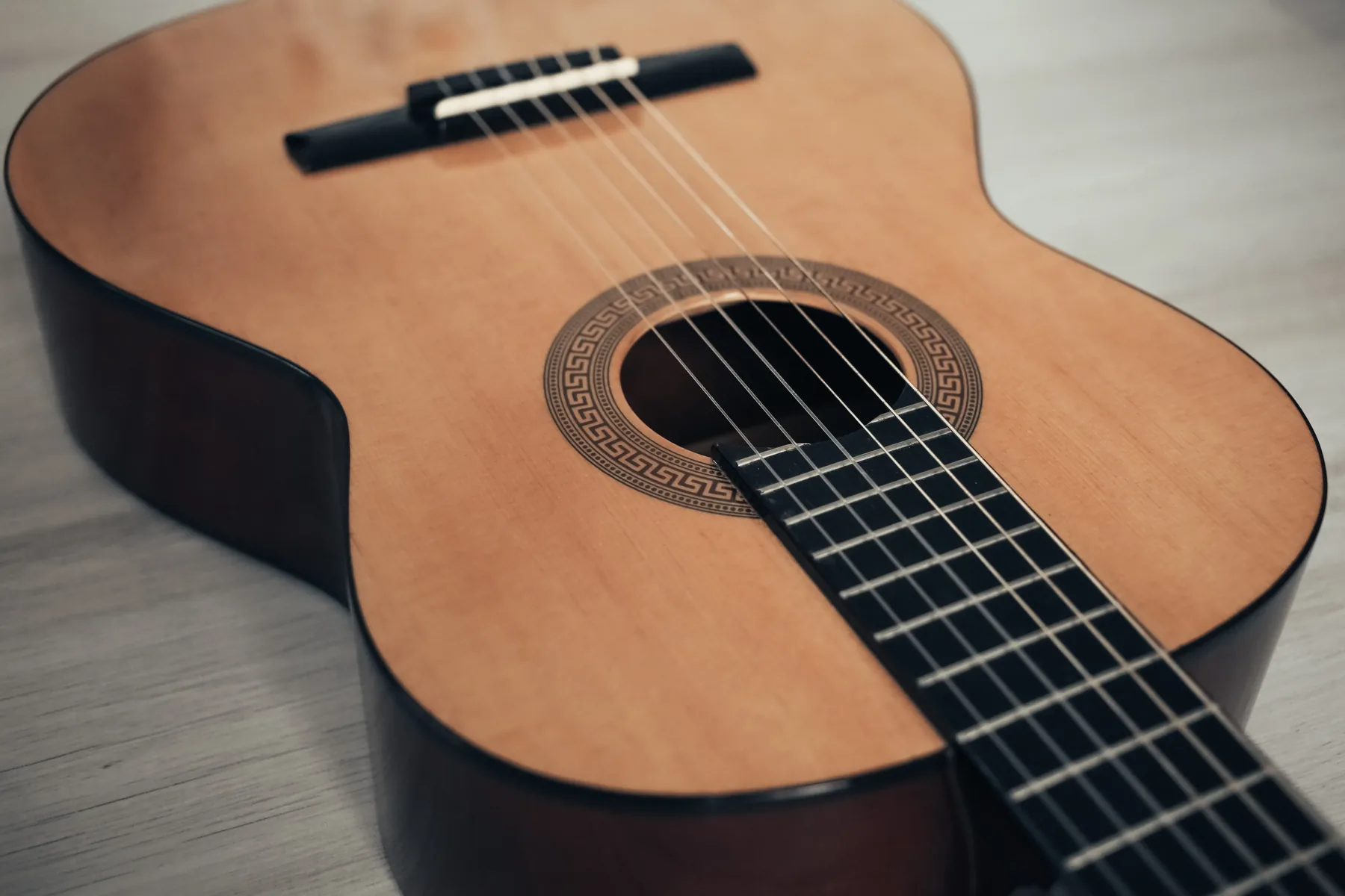Close-up van snaren, kam en klankkast van een klassieke gitaar