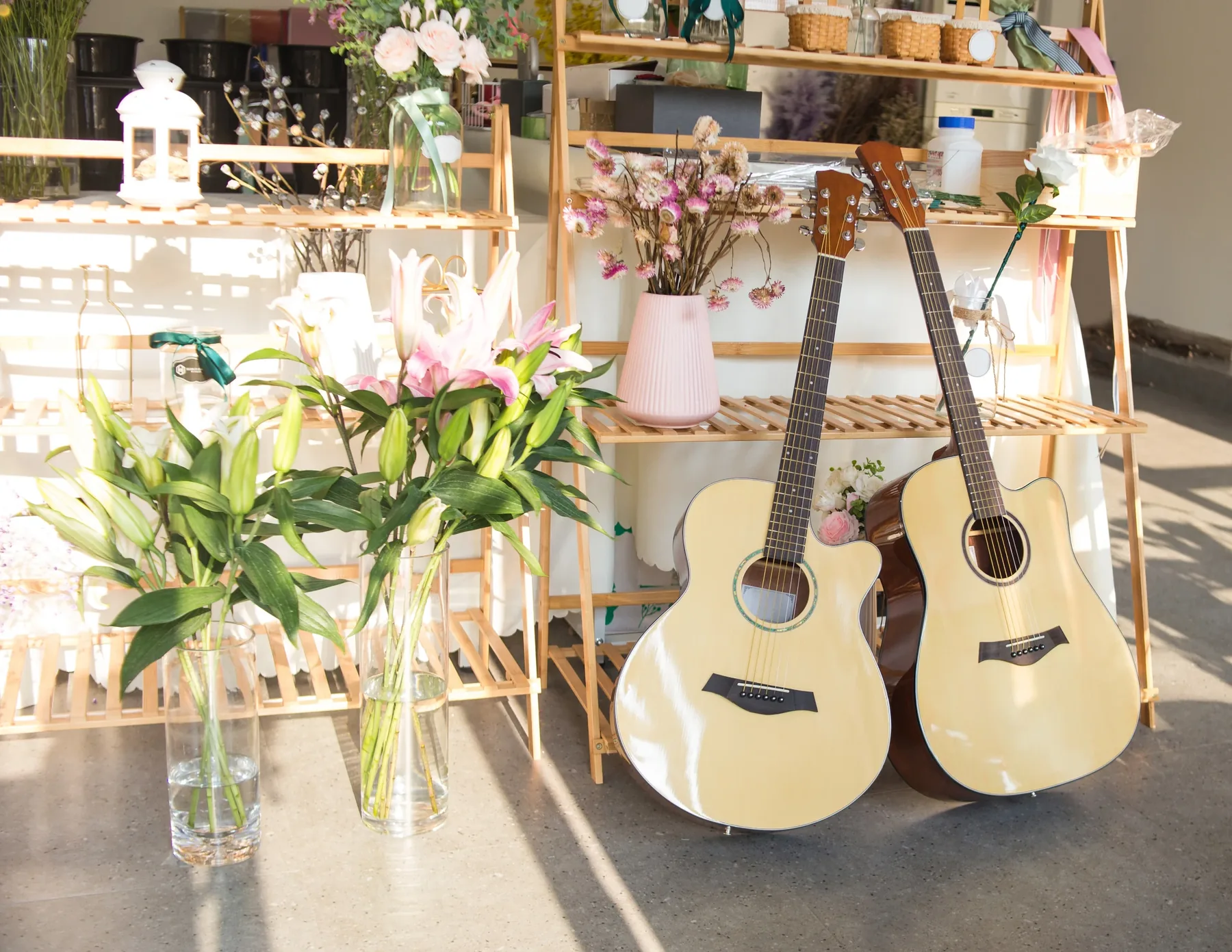 Two classical guitars beside flowers and wedding decorations.